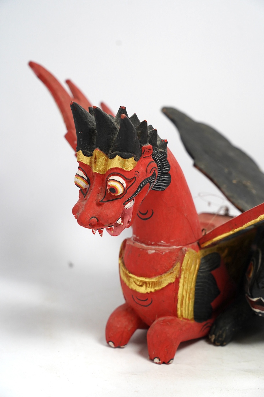 Two Balinese carved and painted wood winged creatures, largest 44cm long. Condition - fair